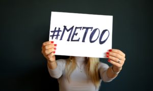 Woman holds up a #MeToo sign