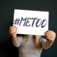 Woman holds up a #MeToo sign